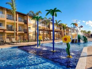 Resort Ondas Praia في بورتو سيغورو: مسبح في منتجع فيه نافورة و نخيل