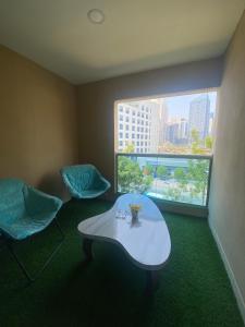 a room with two chairs and a table and a window at Luxury 2BR with balcony in the heart of Dubai Marina, The Belvedere Happy Home in Dubai
