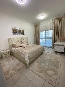 a bedroom with a large bed and a large window at Luxury 2BR with balcony in the heart of Dubai Marina, The Belvedere Happy Home in Dubai