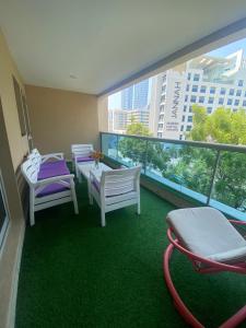 a room with chairs and a table and a balcony at Luxury 2BR with balcony in the heart of Dubai Marina, The Belvedere Happy Home in Dubai