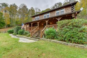 a large log cabin with a porch and a flag at Home with Indoor Spa 8 Mi to Smoky Mtn Natl Park! in Waynesville
