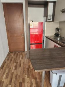 a kitchen with a wooden counter and a red refrigerator at Gamero a Pasos de Metro Hospitales in Santiago