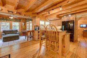 a kitchen and living room with wooden walls and wood floors at Home with Indoor Spa 8 Mi to Smoky Mtn Natl Park! in Waynesville