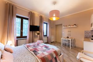 1 dormitorio con 1 cama, TV y mesa en Le fantasie di Tizi, en Alpignano