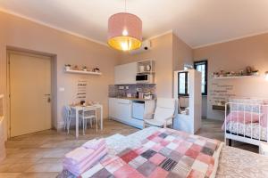 a bedroom with a bed and a kitchen in a room at Le fantasie di Tizi in Alpignano