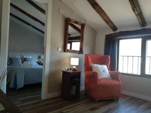 1 dormitorio con cama, silla y espejo en Casa rural abuela Gaspara, en Alcalá del Júcar