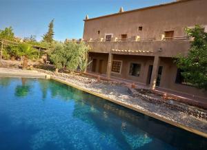 a pool of water in front of a building at RIAD AMAN SKOURA in Skoura