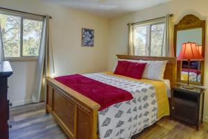 ein Schlafzimmer mit einem Bett, einer Lampe und zwei Fenstern in der Unterkunft Cozy Prescott Retreat with Thumb Butte Nature Views! in Prescott