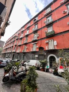 een rood gebouw met auto's ervoor geparkeerd bij Chiaia Exclusive Apartment in Napels