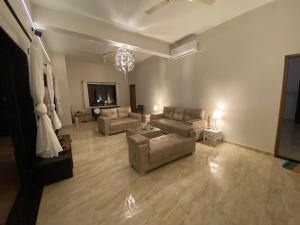 a living room with two couches and a tv at Jessica’s Vacation Home in Banda