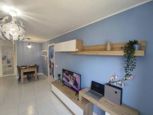 salon z telewizorem i niebieską ścianą w obiekcie Team019 Sitges Richard España w mieście Sant Pere de Ribes