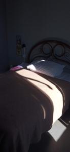 a bed in a dark room with a white pillow at Lapa Bed and breakfast Apartamento Rio de Janeiro in Rio de Janeiro