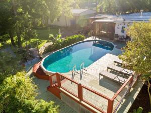 een uitzicht op een zwembad met een houten terras bij Escape To Willow Springs Inn, Cozy Home Wa View 