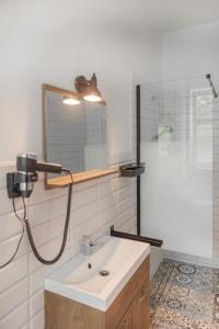 uma casa de banho com um lavatório, um chuveiro e um espelho. em Neu möbliertes 1 - Zimmerapartment mitten in der Natur em Neu Gaarz