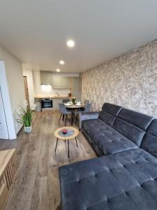 ein Wohnzimmer mit einem Sofa und einem Tisch in der Unterkunft Malūno apartamentai in Klaipėda