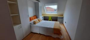 Habitación pequeña con cama y ventana en LAS ALBRICIAS en León