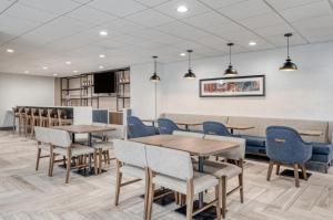 a waiting area with tables and chairs in a waiting room at Holiday Inn Express Federal Way - Seattle South, an IHG Hotel in Federal Way