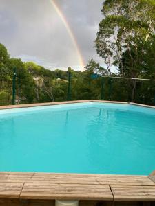 a rainbow over a swimming pool with a rainbow at Maison du soleil in Les Abymes