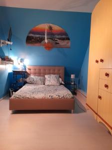 a bedroom with a bed and a blue wall at VÉNUS in Dessenheim
