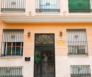 een gebouw met een zwarte deur en ramen bij NEW Tropic Malaka Home in Málaga