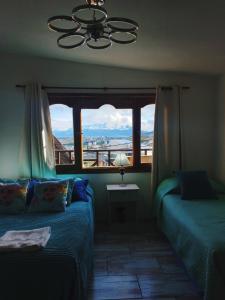 ウシュアイアにあるUshuaia magnífica, cabaña 3 dormitoriosのベッドルーム1室(ベッド2台付)、景色を望む窓が備わります。