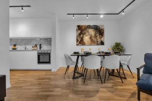 une salle à manger avec une table et des chaises ainsi qu'une cuisine dans l'établissement The Urban City Haven, à Tromsø