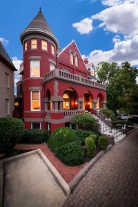 une grande maison rouge avec une tourelle dans une rue dans l'établissement Swann House, à Washington