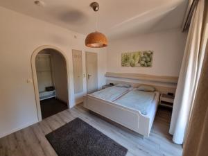 - une chambre avec un lit blanc et un miroir dans l'établissement Malerhaus Ferienwohnungen, à Bad Reichenhall