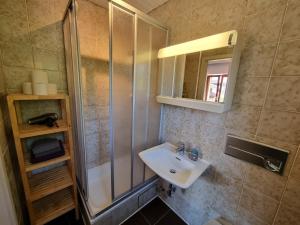 La salle de bains est pourvue d'un lavabo et d'une douche. dans l'établissement Malerhaus Ferienwohnungen, à Bad Reichenhall