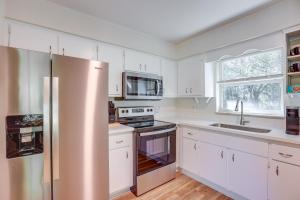 a kitchen with white cabinets and a stainless steel refrigerator at Williston Home with Yard 6 Mi to Devils Den Spring! in Williston