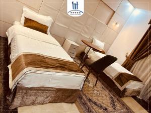 um quarto com 2 camas individuais e uma mesa em Gulf Tower em Karbala