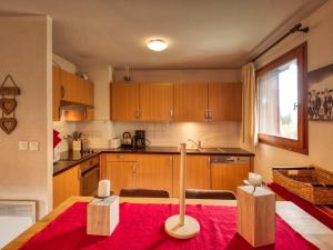 a kitchen with wooden cabinets and a red rug at Appartement Morillon 1100, 5 pièces, 10 personnes - FR-1-642-4 in Morillon
