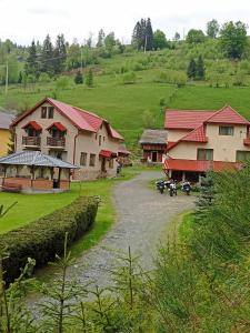 uma aldeia com casas e um rio num campo em Pensiunea Sofy em Arieşeni