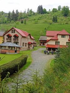 a village with houses and a river in a field at Pensiunea Sofy in Arieşeni