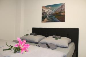 duas camas com lençóis brancos e uma flor rosa em Mont Apartments em Düsseldorf