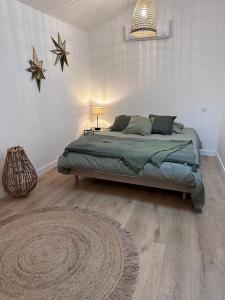 1 dormitorio con cama y alfombra en el suelo en La maison de Mounette, en LʼIsle-dʼAbeau