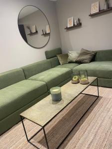 a living room with a green couch and a table at La maison de Mounette in LʼIsle-dʼAbeau