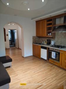a kitchen with wooden cabinets and a wooden floor at Senlejas Apartamenti in Ogre