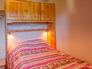 1 dormitorio con 1 cama y armario de madera en Appartement Morillon 1100, 2 pièces, 4 personnes - FR-1-642-64, en Morillon