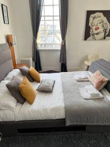 una camera da letto con un letto con cuscini sopra di Russell Square Apartment a Brighton & Hove
