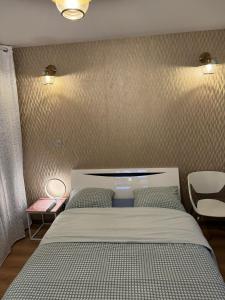 1 dormitorio con cama y pared en Chambre privée/Climatisée+TV /Pétit dejeuner inclu/Tout confort, en Nevers