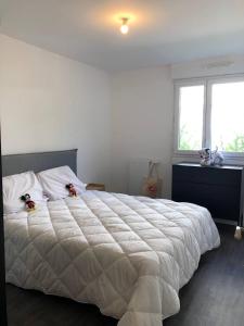 a bedroom with a large white bed with two stuffed animals on it at l'Éden familial - cosy F3 proche Disneyland avec jardin in Vaires-sur-Marne