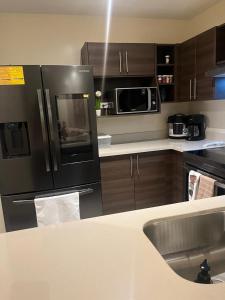 a kitchen with a black refrigerator and a sink at Departamento en brasil in Rio de Janeiro