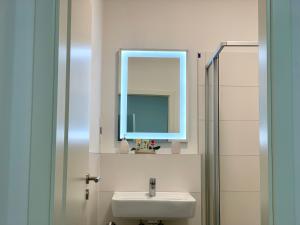 un baño con lavabo y espejo en Mont Apartments, en Düsseldorf 35 fotos más