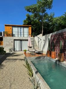 a backyard with a swimming pool and a house at Naari Cabañas Boutique in Brisas de Zicatela