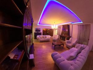 a living room with a couch and chairs and a tv at F C Tiranë in Tirana