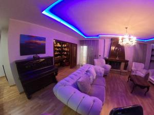 a purple living room with a couch and a tv at F C Tiranë in Tirana