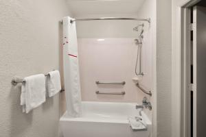 a bathroom with a shower and a toilet with towels at Red Roof Inn Binghamton - Johnson City in Binghamton +26 photos