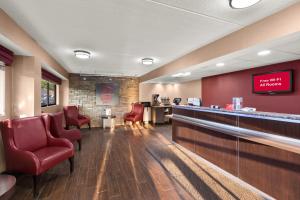 a waiting room with red chairs and a bar at Red Roof Inn Binghamton - Johnson City in Binghamton