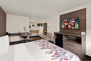 ein Hotelzimmer mit einem Schlafzimmer mit einem Bett und einem Schreibtisch in der Unterkunft Red Roof Inn Binghamton - Johnson City in Binghamton